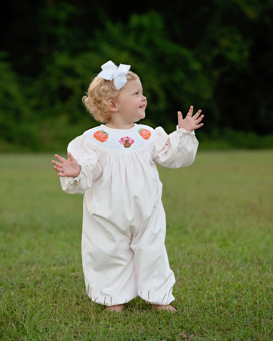 Young girl wearing pink dot turkey and pumpkin long bubble.