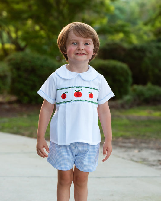 boy in white pumpkin shirt and blue plaid shorts
