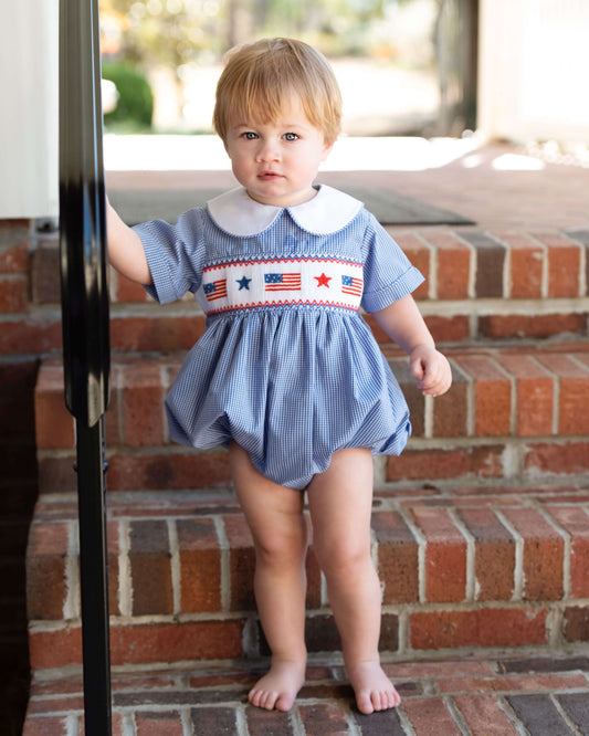 boy standing by some stairs wearing a navy patriotic outfit