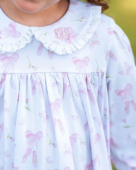 Close-up of a child's dress with floral pattern and white collar.