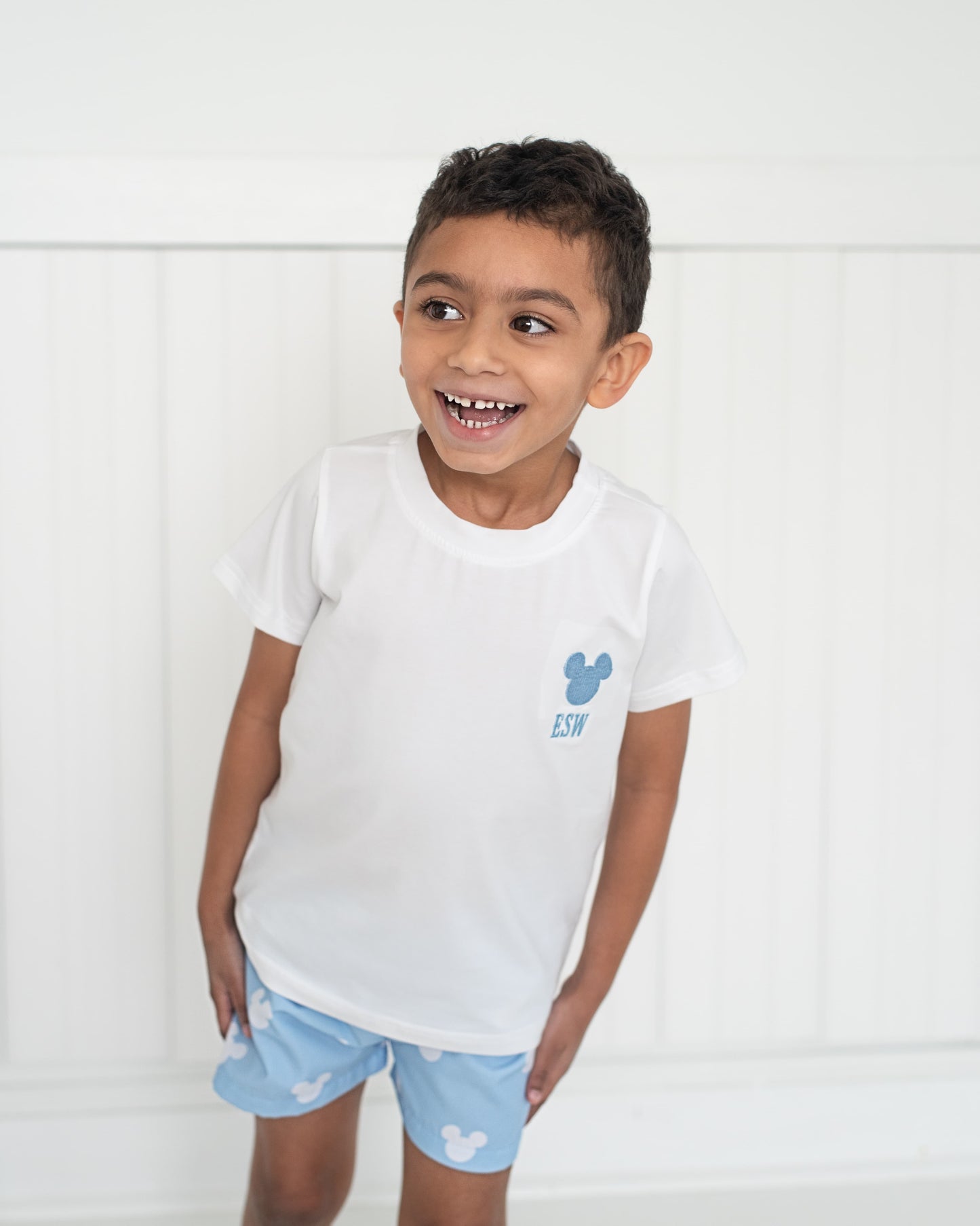 little boy wearing a blue mouse ears short set
