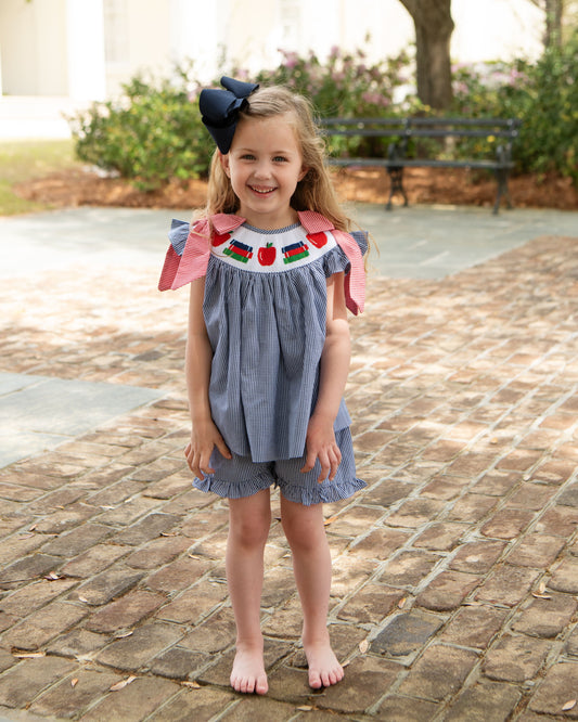 little girl wearing a smocked back to school short set