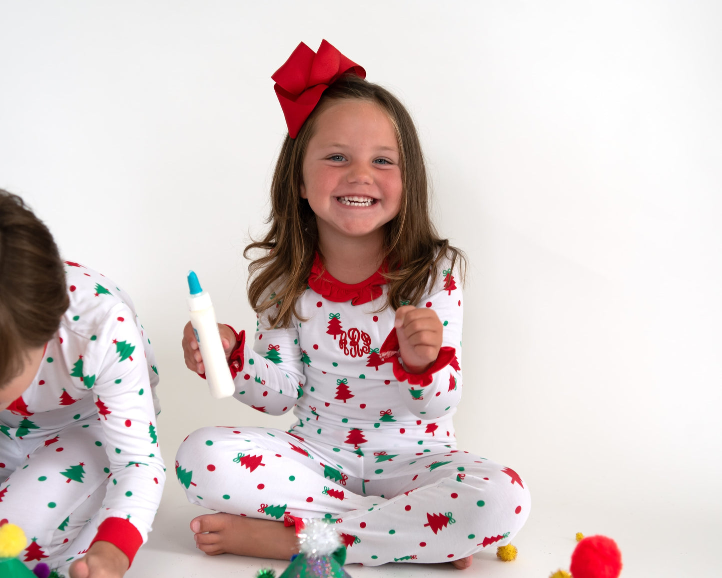 Personalized Christmas tree ruffle pajamas for girls with red trim, monogram detail, and holiday print