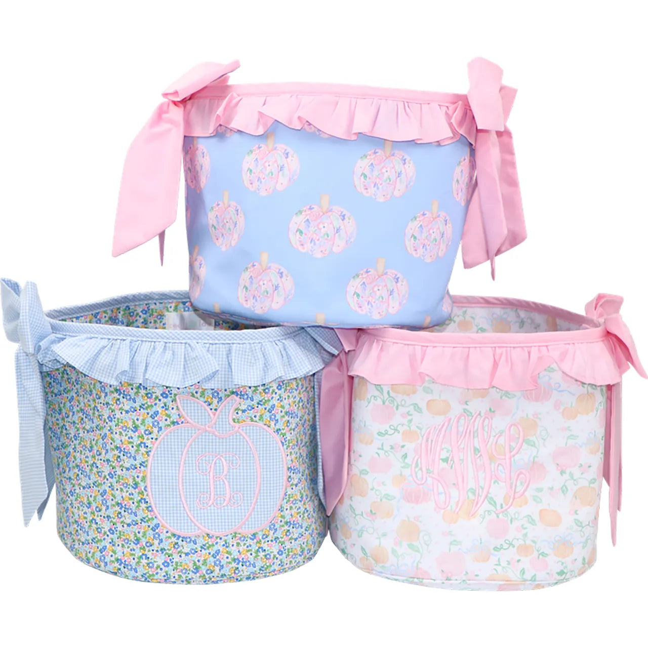 Three decorative storage bins with floral patterns and pink ribbons on a white background