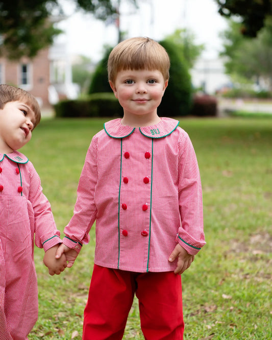 Two children in matching pink and red outfits standing outdoors.