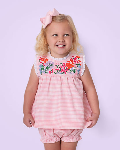 Young girl wearing a pink floral dress with a lavender background