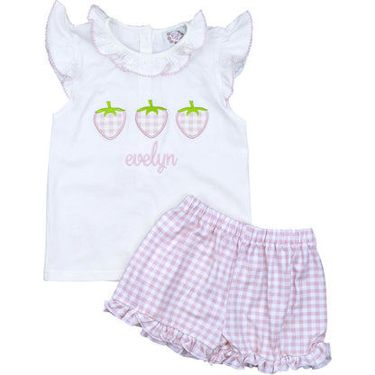 White tank top with strawberry design and checkered shorts on a white background