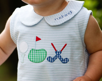Baby dress with sports-themed appliqués on a blurred background