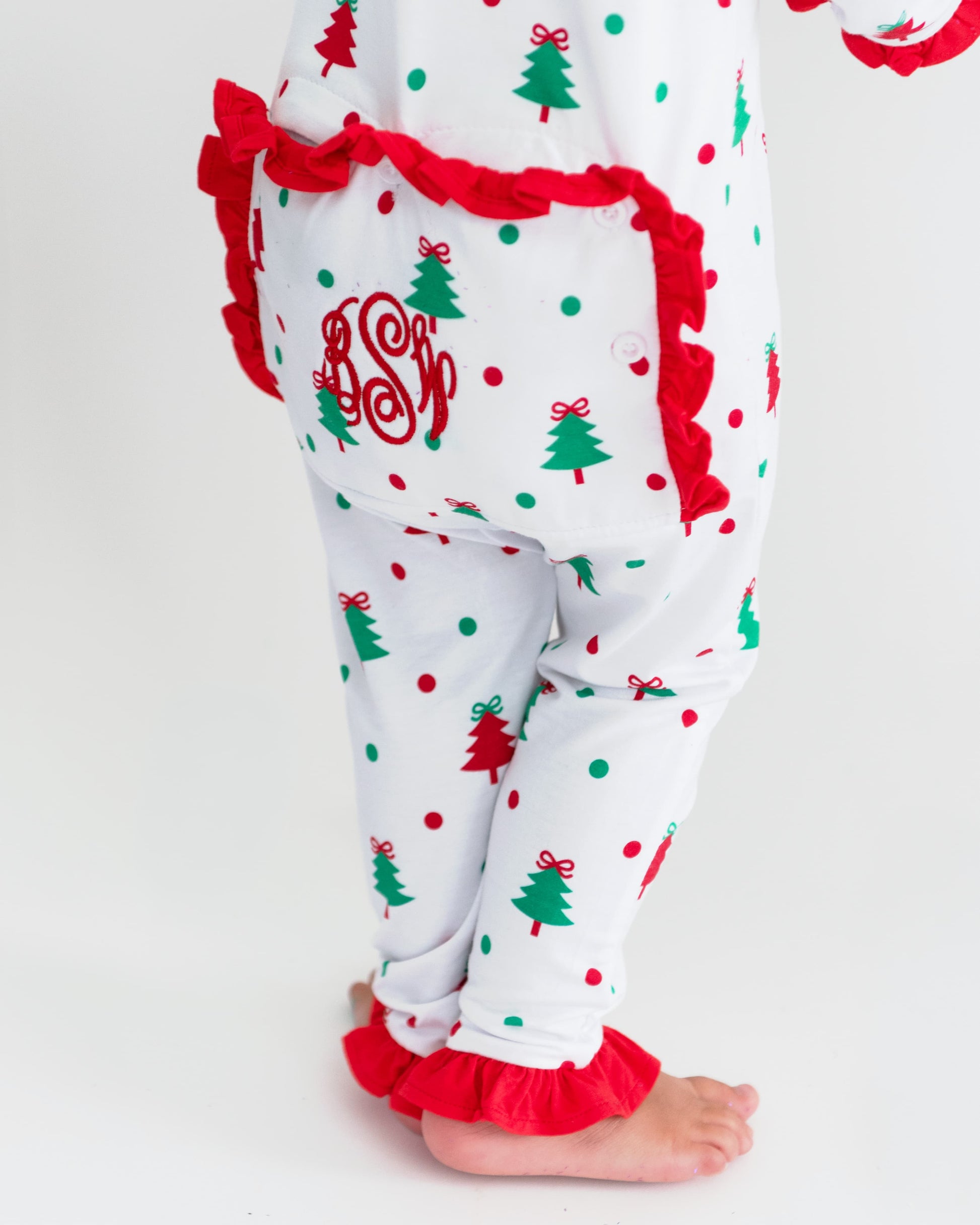 Back view on Christmas pajamas showing a monogram and ruffle trim