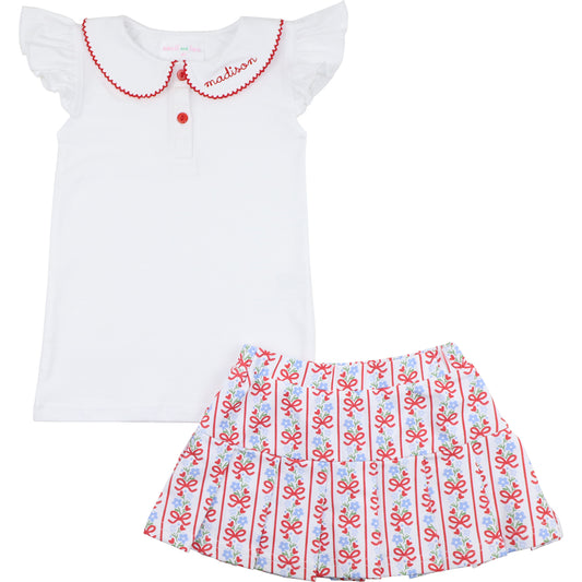 White top with red trim and a patterned skirt on a white background