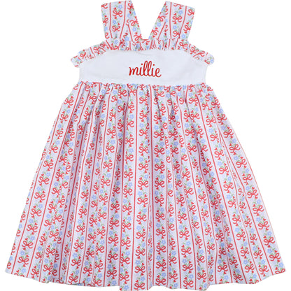 Children's dress with red and blue pattern and 'millie' embroidered on the chest.
