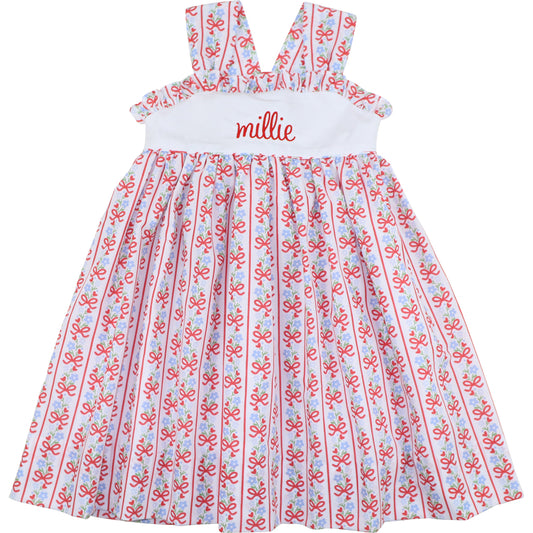 Children's dress with red and blue pattern and 'millie' embroidered on the chest.