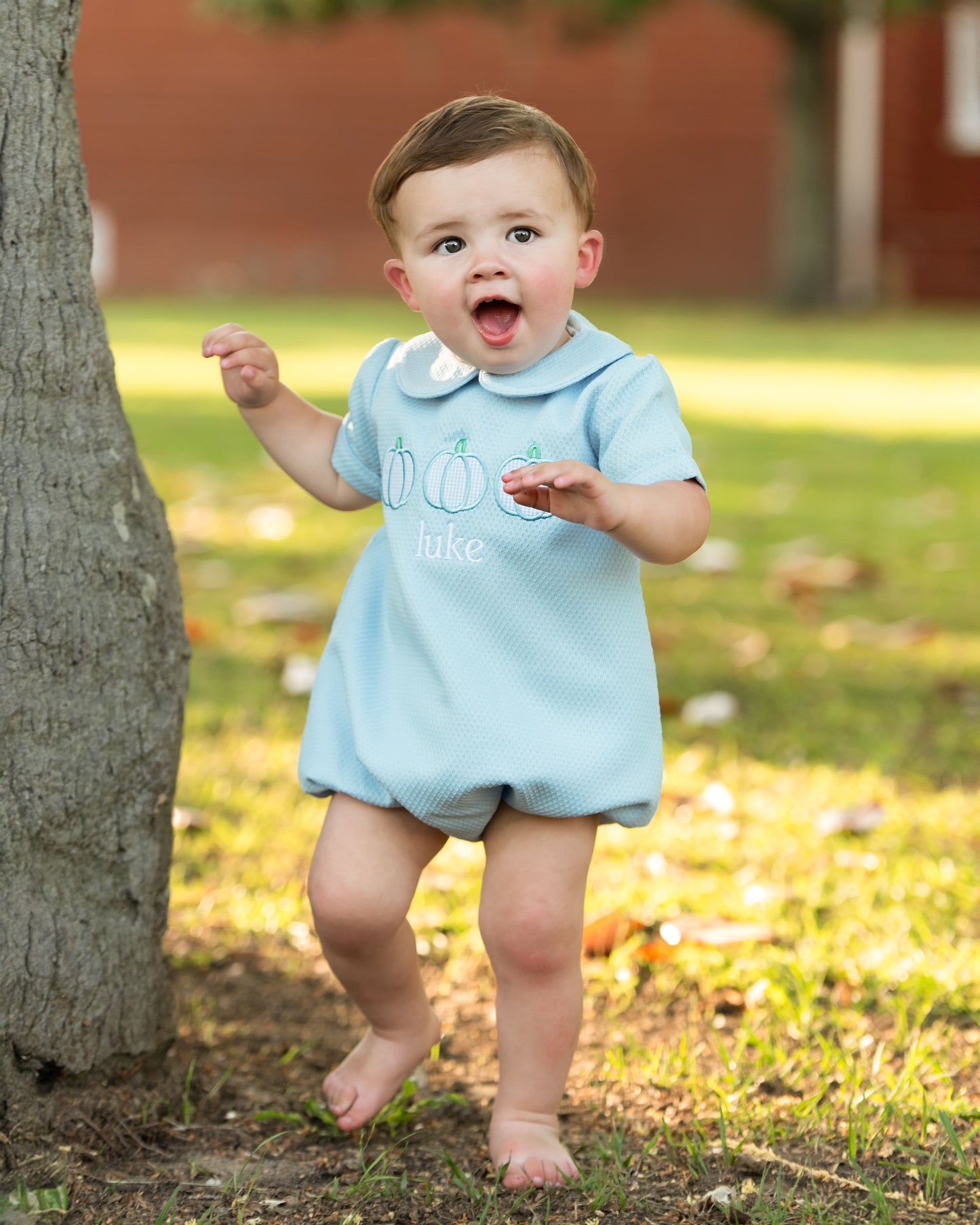 Blue bubble with pumpkin designs standing outdoors near a tree