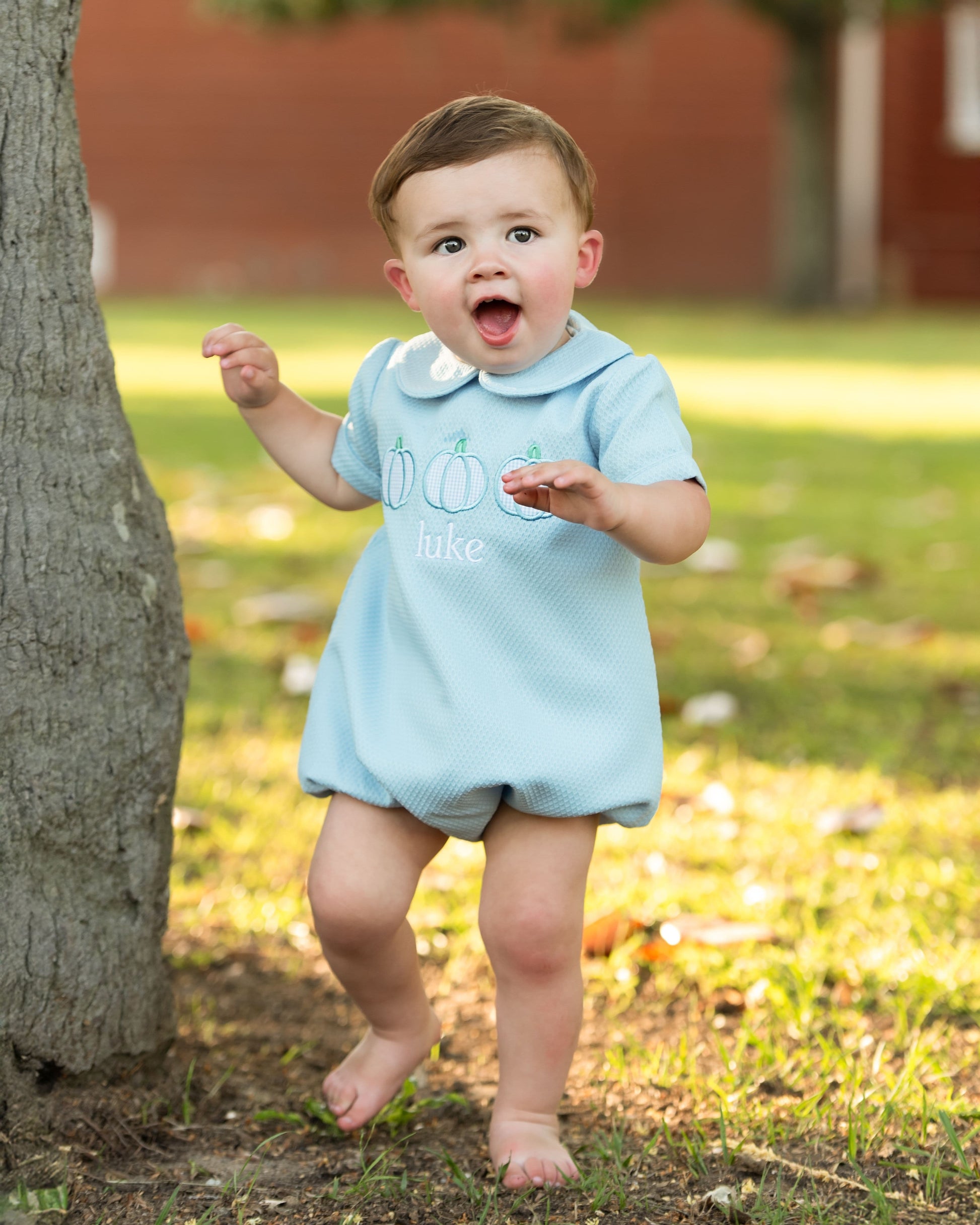 Blue bubble with pumpkin designs standing outdoors near a tree