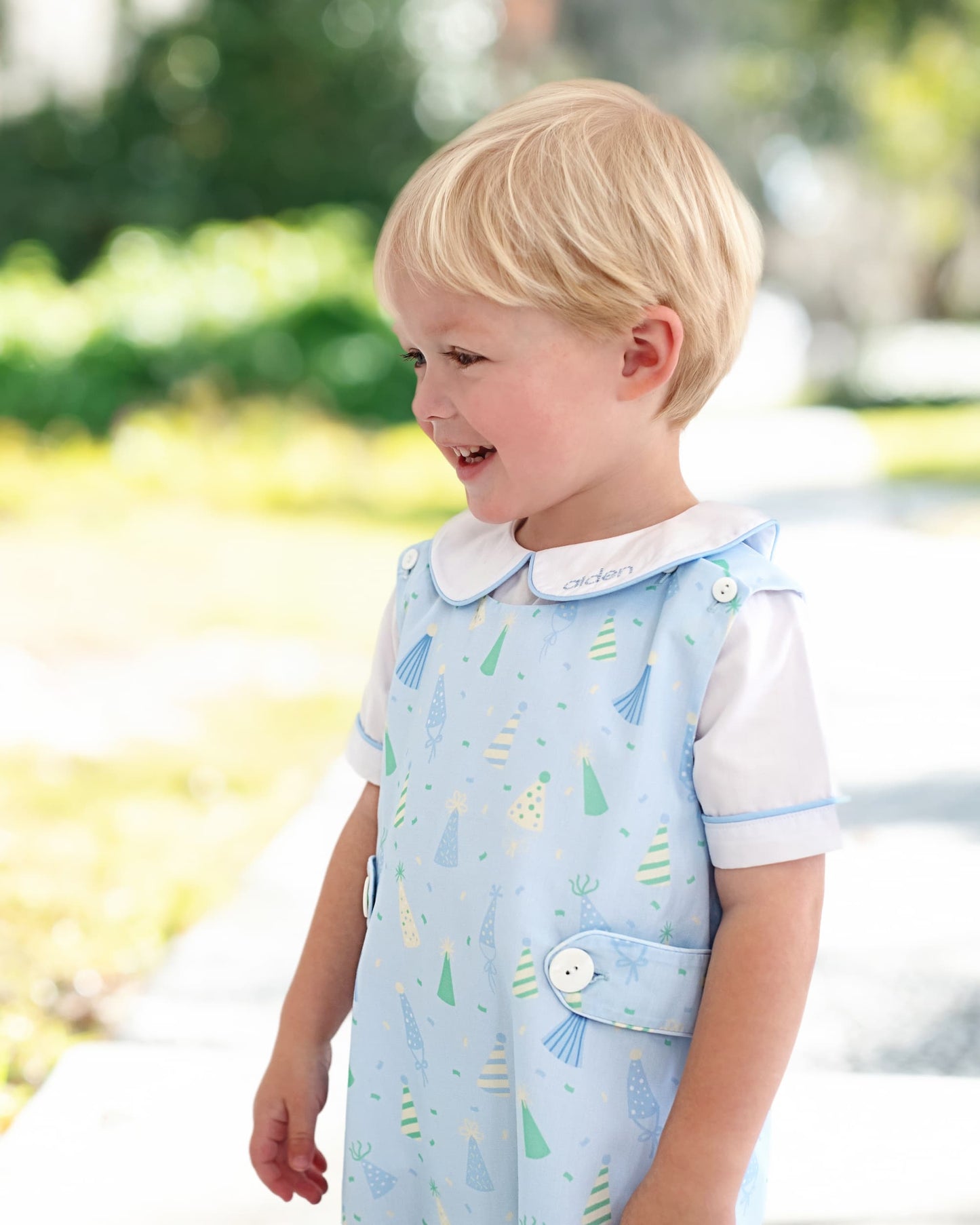 Boy wearing a birthday outfit smiling 