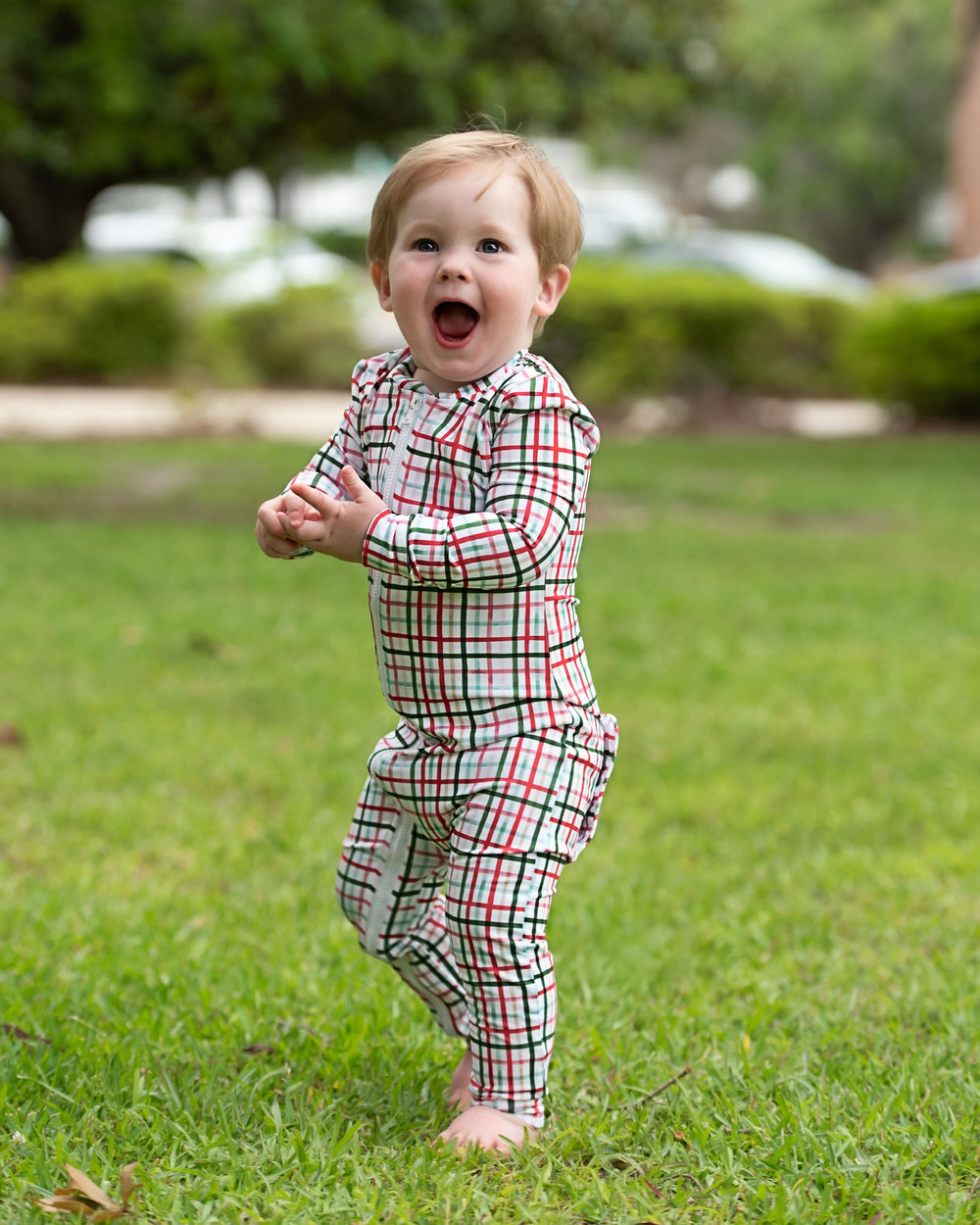 Baby wearing red and green plaid Christmas zipper pajamas