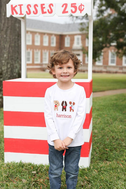 Child standing in front of a red and white striped candy stand with a sign reading 'Kisses 25 cents'.