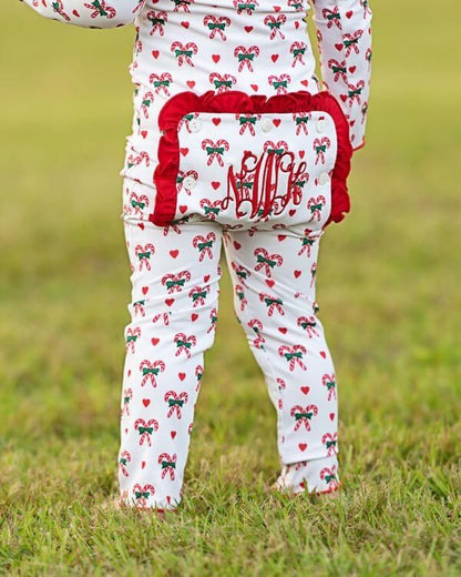 Child wearing a Christmas-themed outfit with red and green patterns on grass