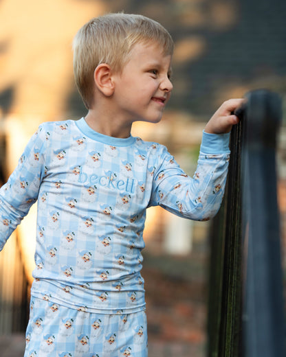 Child wearing a blue long-sleeve shirt with 'beckell' branding outdoors.