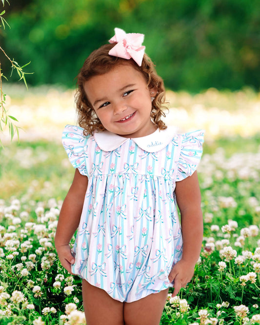 Child wearing a floral dress in a field of flowers