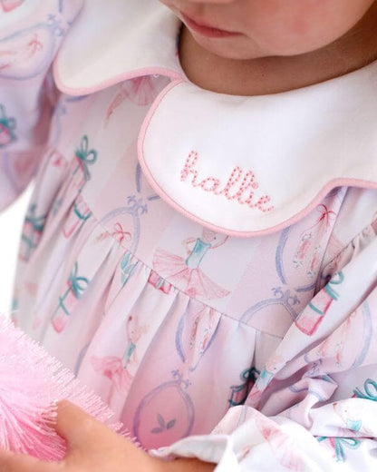 Child_wearing_a_holiday_outfit_with_the_name_hally_embroidered_on_it_holding_a_Christmas_tree_1_1