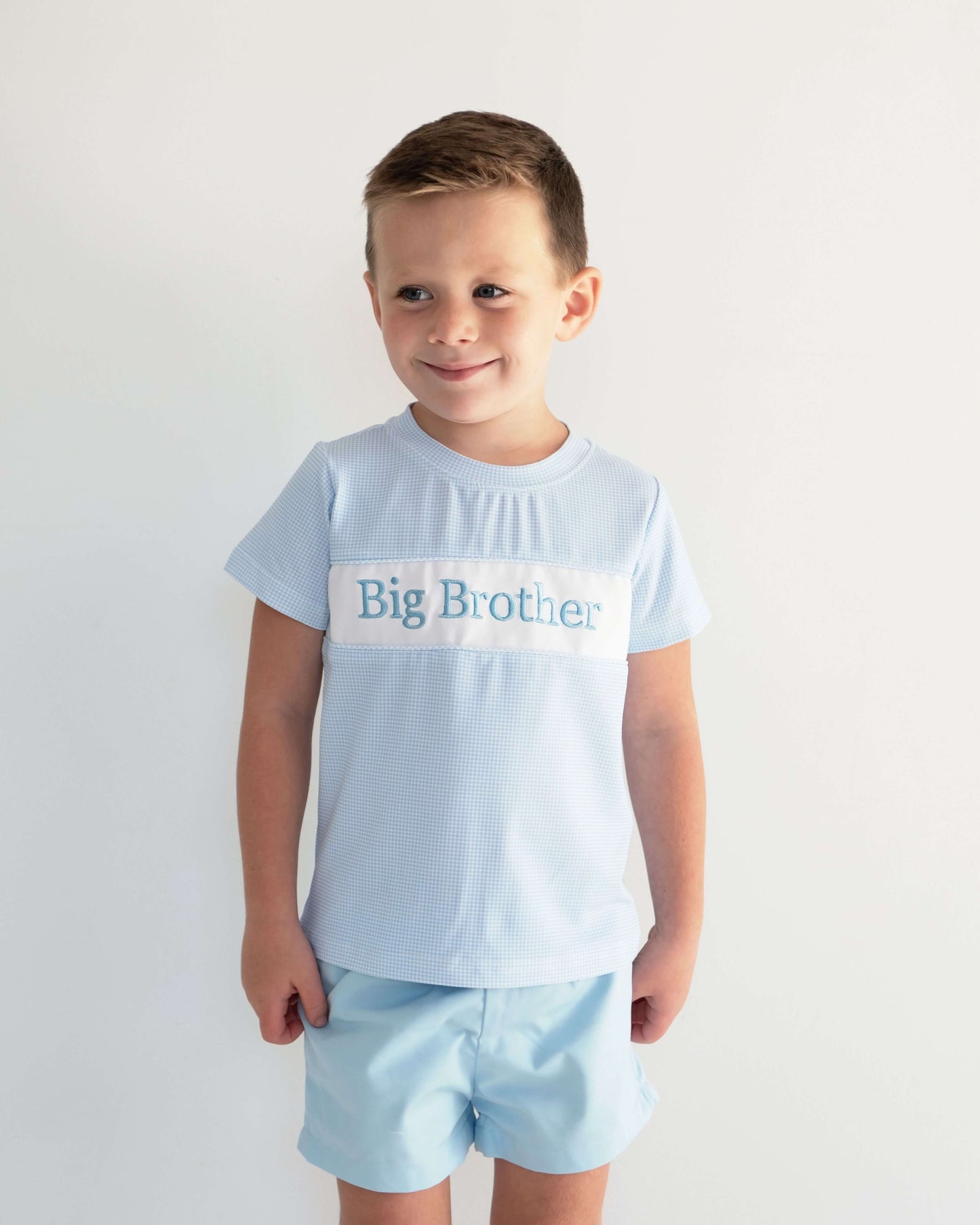 Child wearing a light blue 'Big Brother' t-shirt on a white background