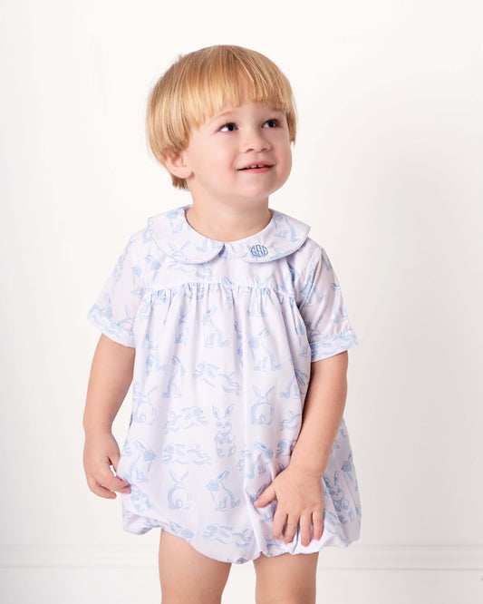 Child wearing a light blue floral dress with a white background