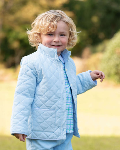 Child wearing a light blue quilted jacket outdoors