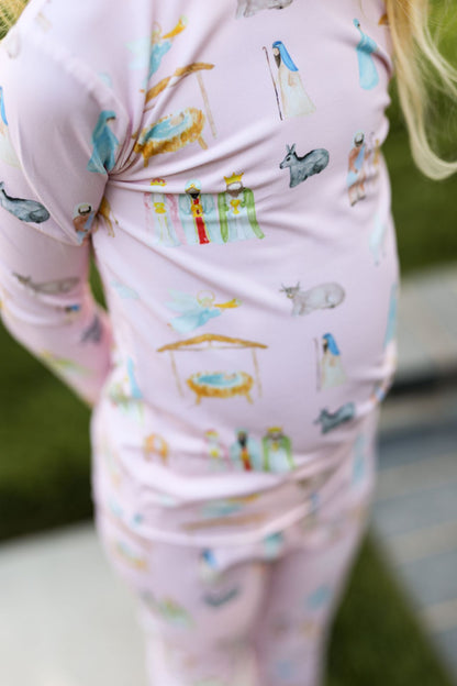 Child wearing a pink outfit with colorful animal prints outdoors.