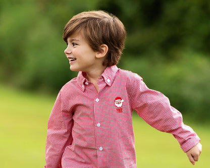 Child wearing a red checkered shirt with a logo outdoors