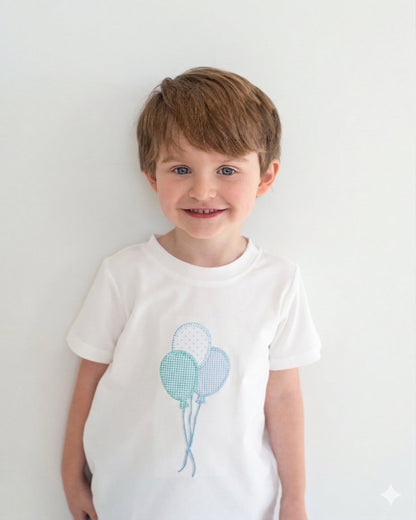 Child wearing a white t-shirt with blue balloon design on a plain background