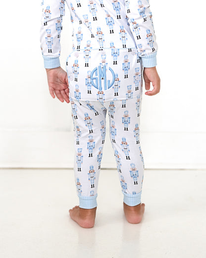 Child wearing pajamas with robot pattern and monogram on a white background