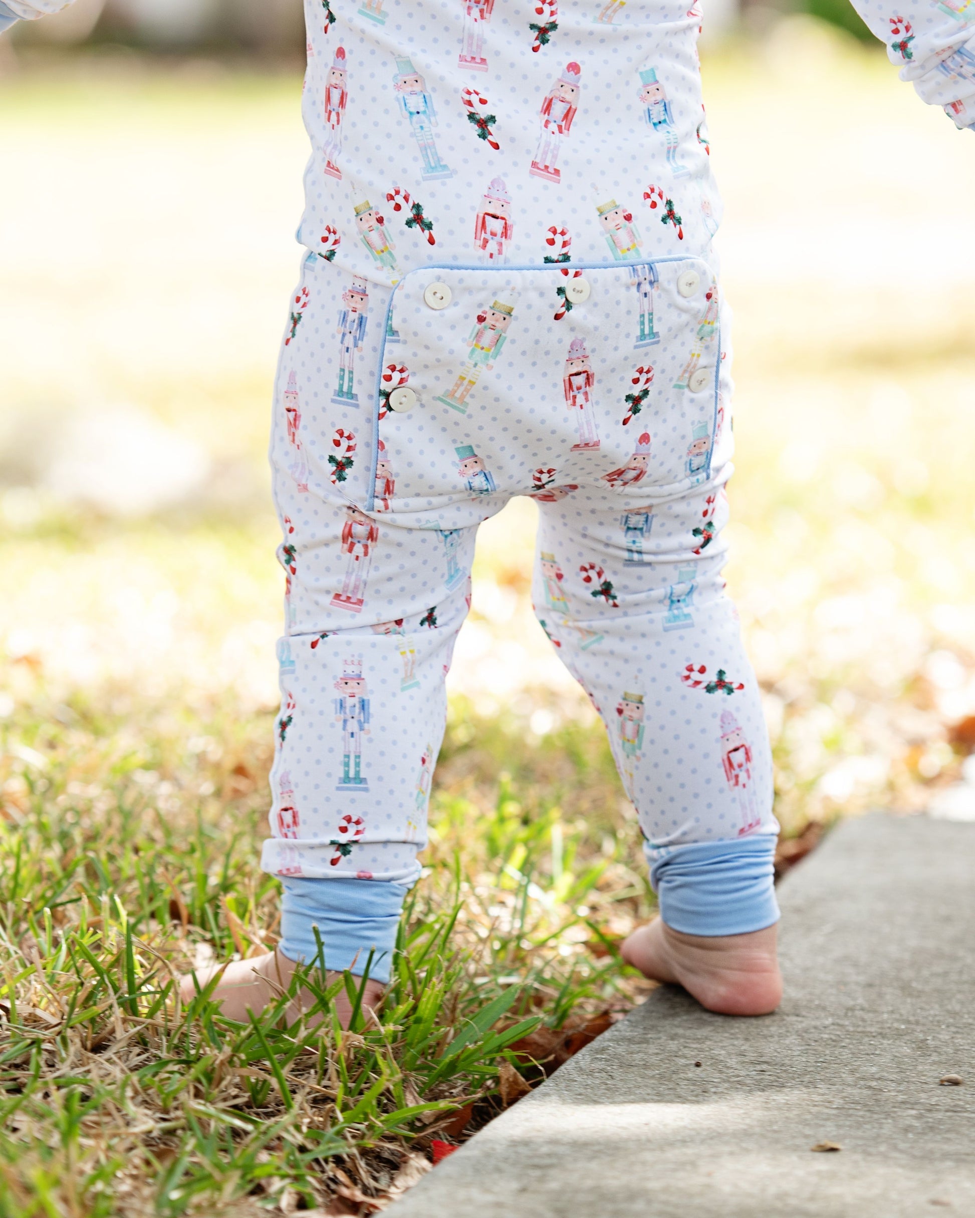 Child wearing patterned pants standing on grass