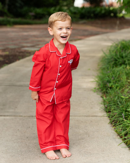 Child wearing red pajamas standing on a sidewalk