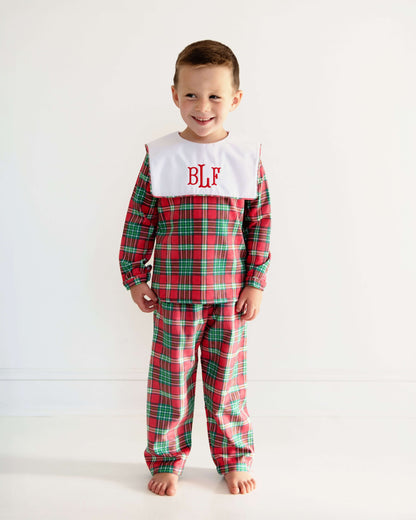 Child wearing red plaid pajamas with a white collar and 'BLF' monogram on a white background