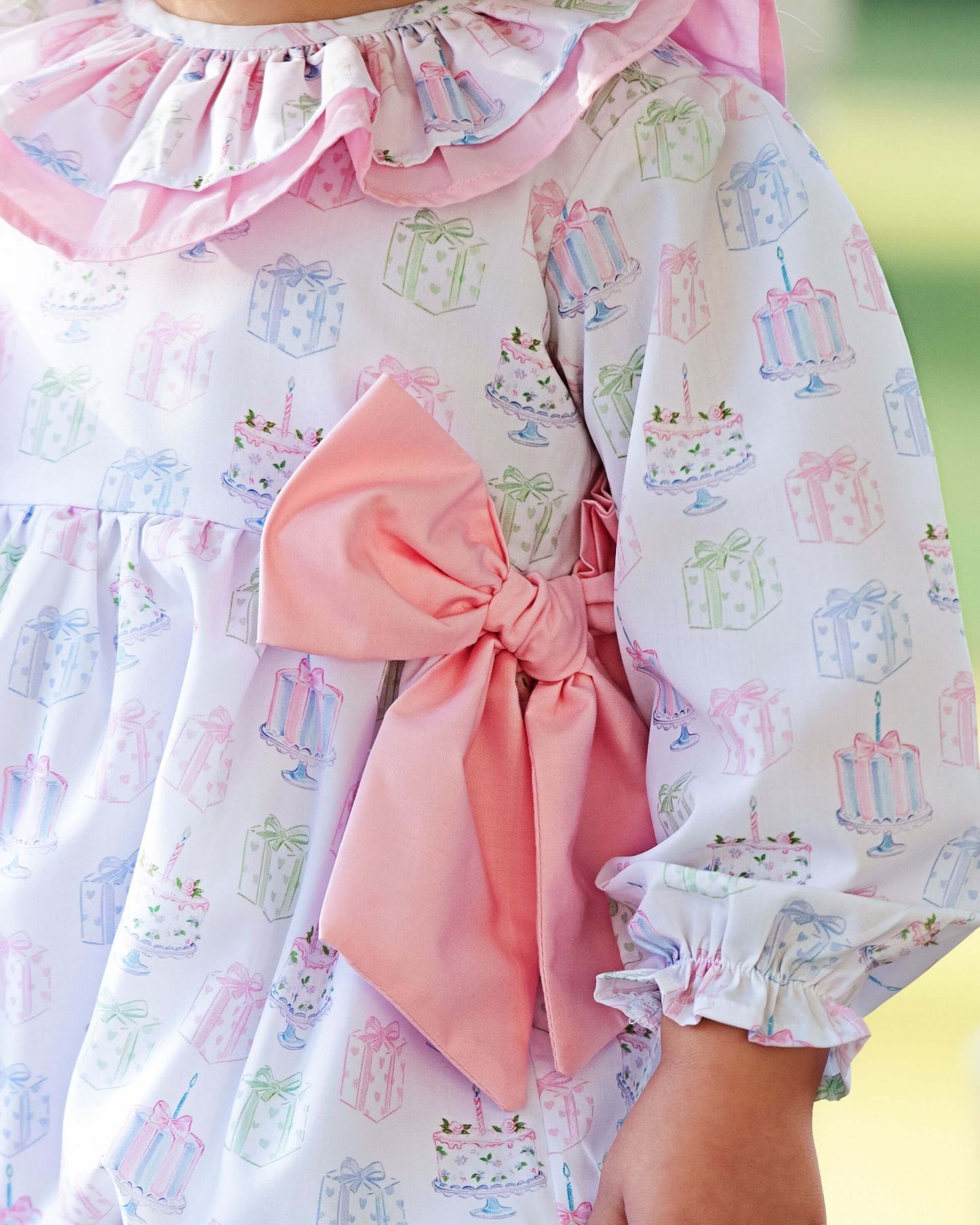 Children's dress with a pink bow and cake pattern