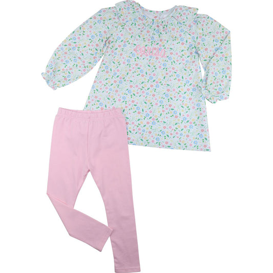 Children's outfit with floral top and pink pants on a white background