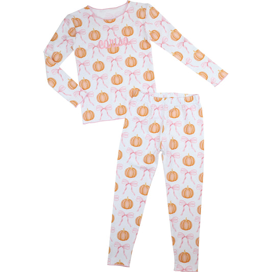 Children's pajama set with pumpkin and bow pattern on a white background