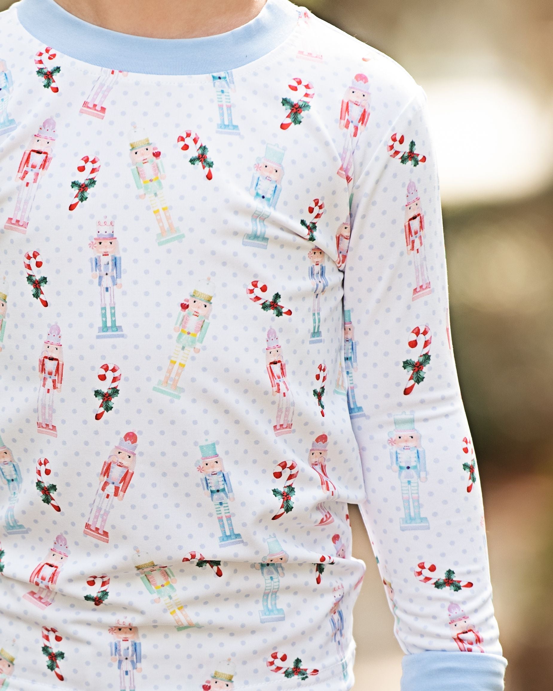 Children's pajama top with nutcracker and candy cane pattern on a blurred background