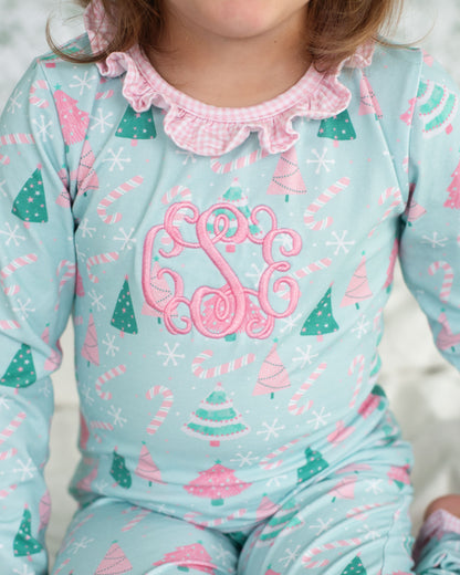 Children's pajamas with Christmas tree and candy cane pattern on a light blue background.