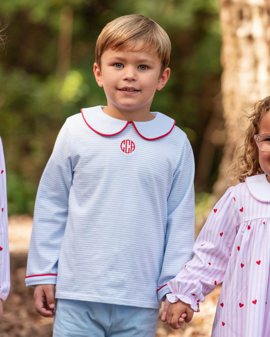 Children wearing matching outfits with a monogram in a forest setting