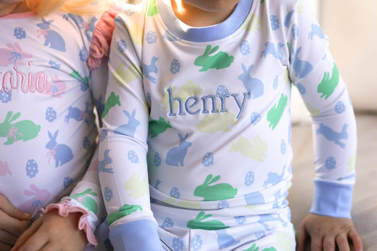 Children wearing pajamas with bunny patterns and 'Henry' printed on them.