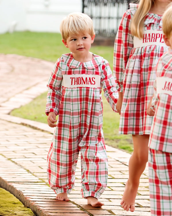 Children wearing personalized red and white plaid custom smocked outfits with their names