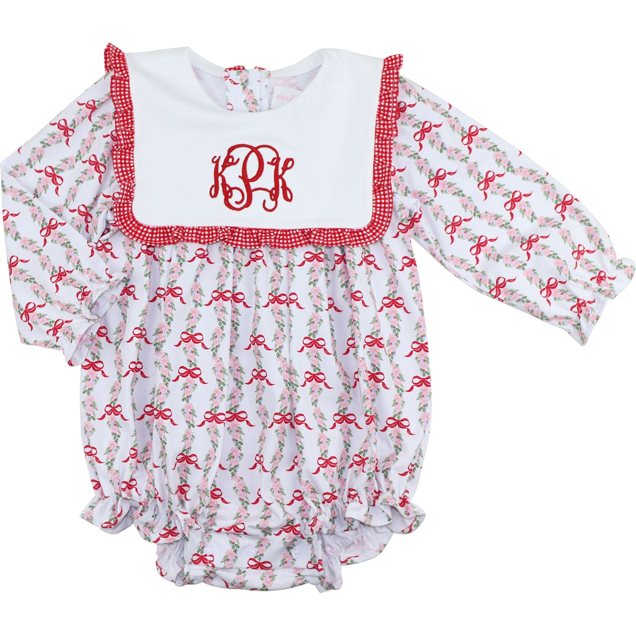 Baby romper with red bows and a white monogrammed top on a white background