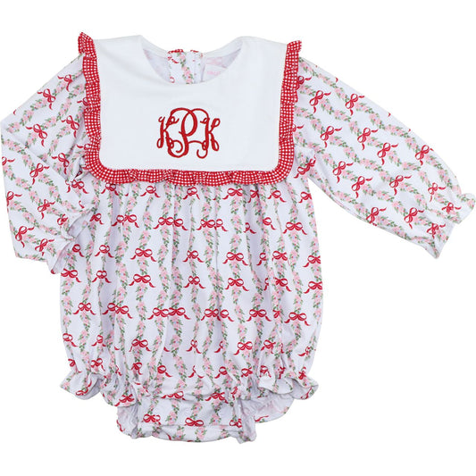 Baby romper with red bows and a white monogrammed top on a white background