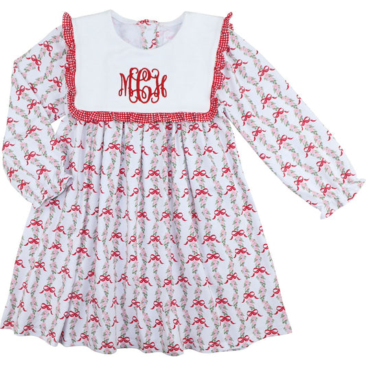 Children's dress with red and white checkered neckline and red bow pattern on a white background
