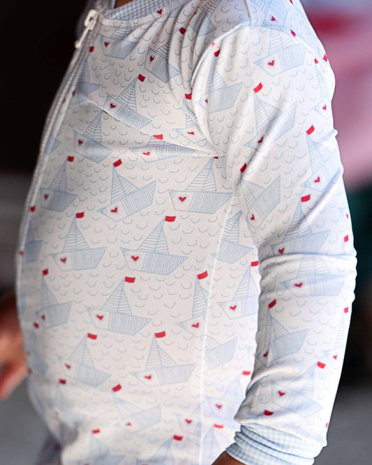 Close-up of a baby's outfit with sailboat pattern