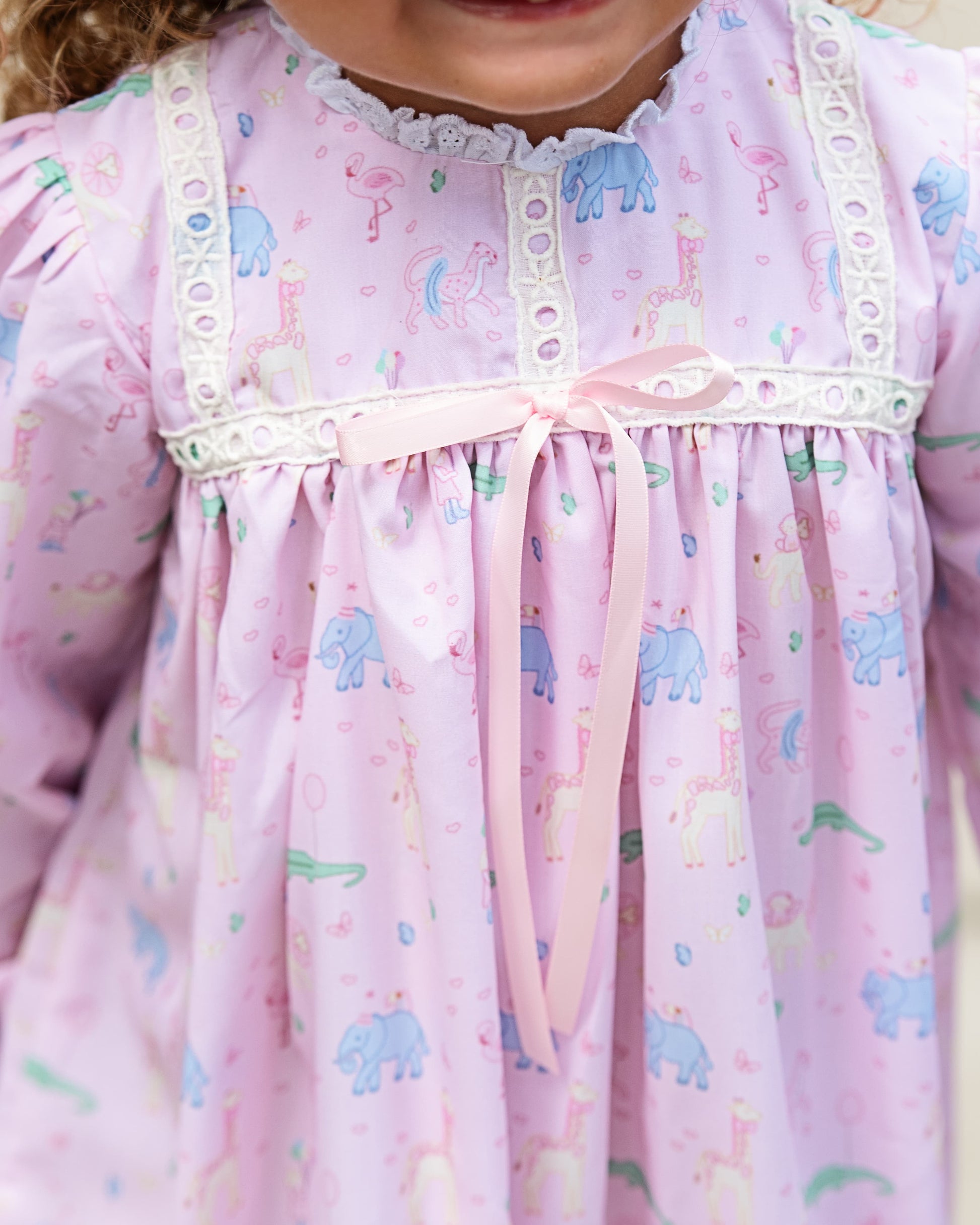 Close-up of a child's pink nightgown with birthday animal prints