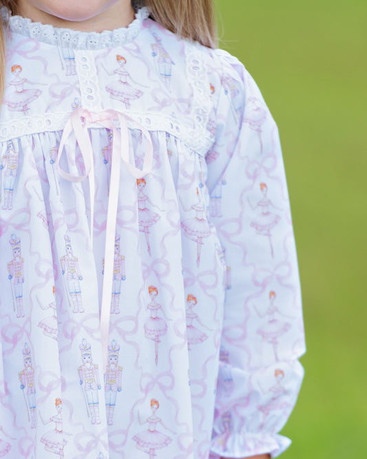 Close-up of a child wearing a nutcracker ballet nightgown against a green background