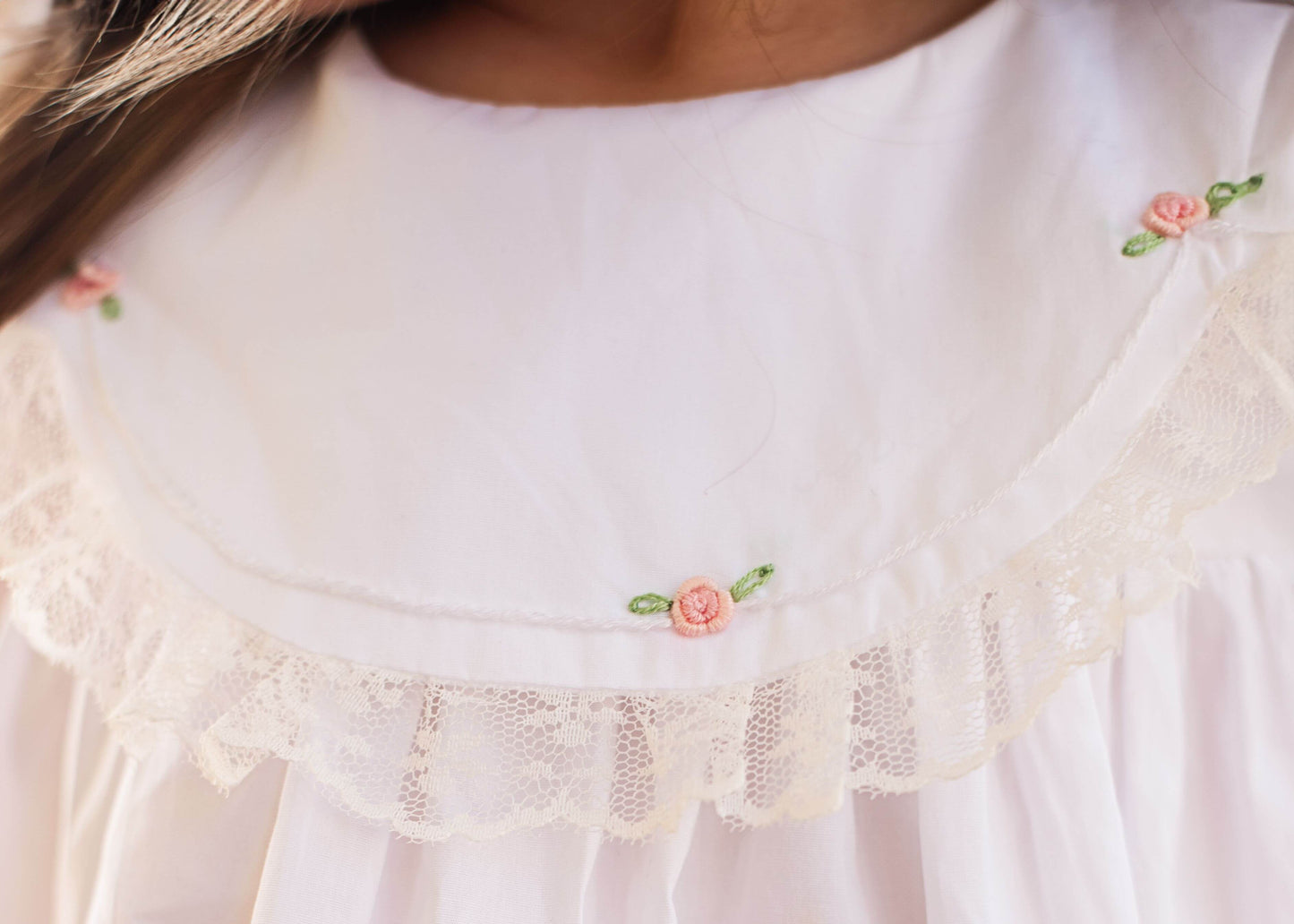 Close-up of a white blouse with floral embroidery details